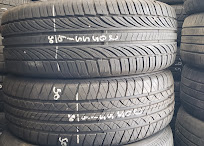 Stacked used tires labeled by size and brand